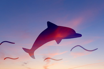 Dolphin silhouette on sunset sky background