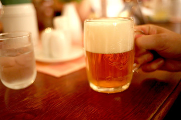 beer mug on a table in a male hand in a pub