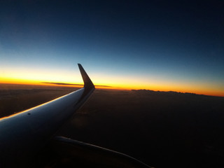 Beautiful sunset from an airplane window with no clould and intense blue.