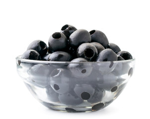 Black pitted olives in a glass plate on a white background. Isolated