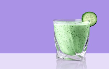 Glass of delicious berry cocktail on purple background