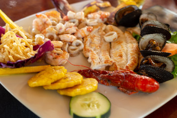 mixed sea food: fried fish, shrimp, shells, and river shrimp, served with french fries and fried plantains, called "patacones".