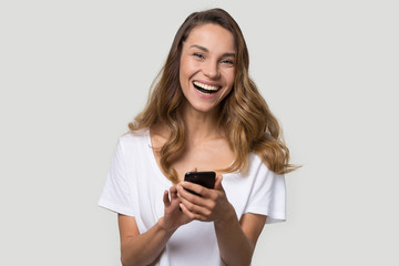 Fototapeta premium Happy laughing young woman using cellphone apps, having fun