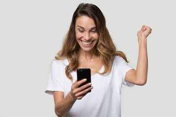 Happy excited woman celebrating success, looking at phone screen