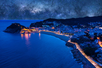The Spanish city of Tossa de Mar located in Costa Brava is a coastal region of Catalonia. Night aerial photo with a starry sky.