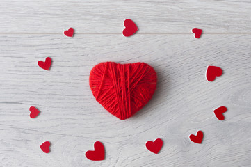 red heart made of yarn against  wood background