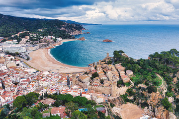 The Spanish city of Tossa de Mar located in Costa Brava is a coastal region of Catalonia. Aerial view. Old city, sea, cloudy sky. - 306196834