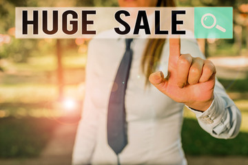 Writing note showing Huge Sale. Business concept for putting products on high discount Great price Black Friday Handsome business girl pointing with finger into empty space