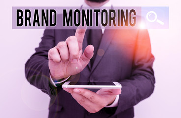 Writing note showing Brand Monitoring. Business concept for process to proactively monitor the brand reputation Male human wear formal work suit hold smartphone using hand