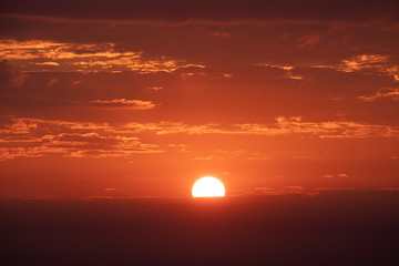 Bright orange sun and red sky during sunrise