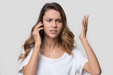 Annoyed angry woman quarreling talking on phone, hearing bad news