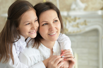 Close up portrait of beautiful young mother and cute little daughter posing