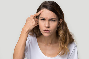 Unhappy young woman touching forehead, worried about acne or wrinkle