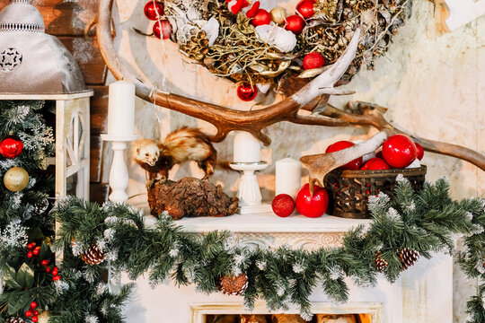 .New Year 2020. Christmas beautiful lights on gold warm background. Christmas tree, toys. Photo of interior of room with a wooden wall, wreath and garlands, fireplace with firewood.