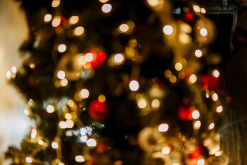 New Year 2020. Christmas beautiful lights bokeh on gold warm background. Defocused Lights on a Tree Background. Christmas tree toys. Golden abstract blinking blurred.