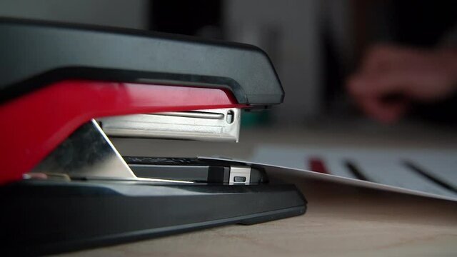 Stapling paper, closeup of man hands in office