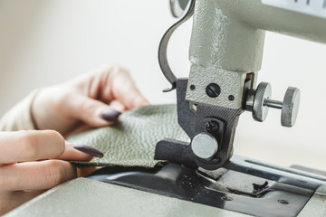 Woman stitching leather using a sewing machine
