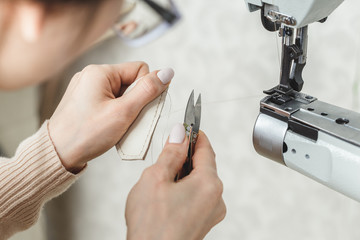 Woman stitching leather using a sewing machine