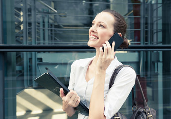 Happy young attractive businesswoman talking on her cell phone. 