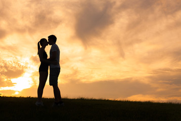 Young couple kissing at sunset. 