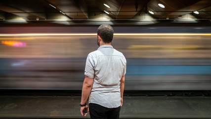 Public transportation train at night with man at station. Long exposure photo, San Francisco,...