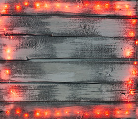 Old wooden background with red lights. Winter banner,