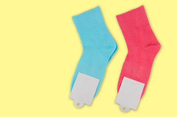 A new pair of socks with a label on a colored background. Colorful socks with white label for your design. Isolated object