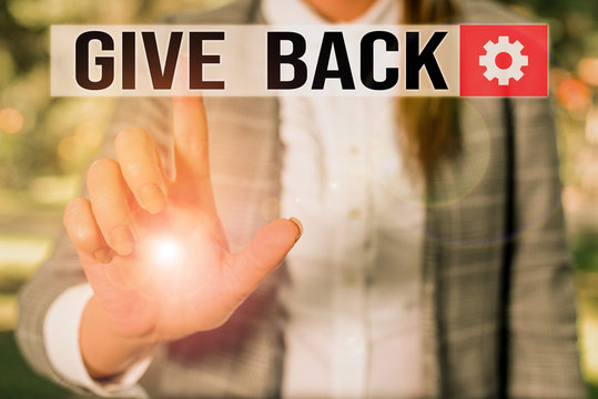 Text sign showing Give Back. Business photo showcasing the act of giving someone something that they owned or had before Business woman in the nature pointing with the finger into empty space
