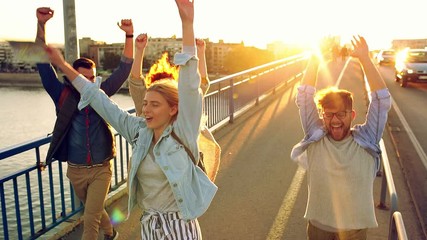 Group of tourists enjoying on vacation, young friends having fun walking on city street during sunset. - Powered by Adobe
