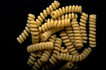 Dried pasta on the dark table, with copy space.