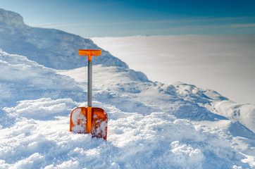 Оrange avalanche shovel in powder fresh snow and place for writing text..