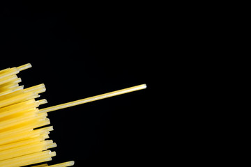 Dried pasta on the dark table, with copy space.