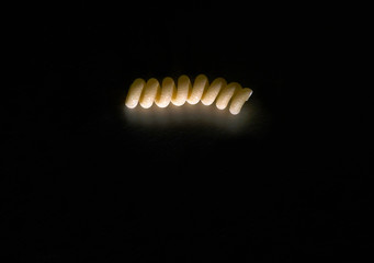 Dried pasta on the dark table, with copy space.