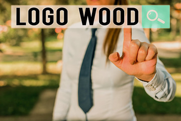Writing note showing Logo Wood. Business concept for Recognizable design or symbol of a company inscribed on wood Handsome business girl pointing with finger into empty space