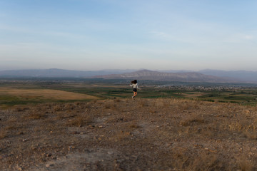 Beautiful and slender Girl travels in Armenia, Yerevan. At sunset, she jump silhouettes against the backdrop of Mount Ararat. Very beautiful landscape