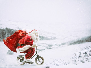 Santa Claus on a little bike on a winter landscape under the snow
