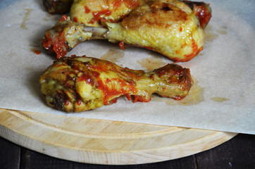 Grilled spicy chicken legs on a black background.Top view. backet chicken on paper