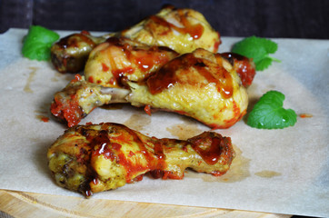 Grilled spicy chicken legs on a black background.Top view. backet chicken on paper