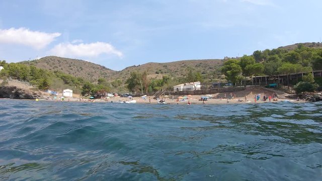 Spain Mediterranean sea, beach coastline in summer and camera moves under water surface to see seagrass Posidonia Oceanica, Costa Brava, Catalonia, Roses