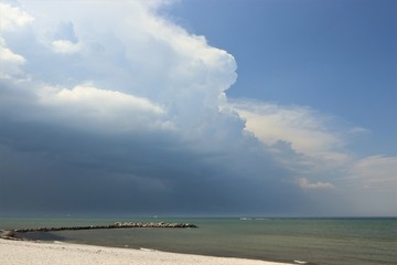 beautiful sandy beach with summer storm over the sea