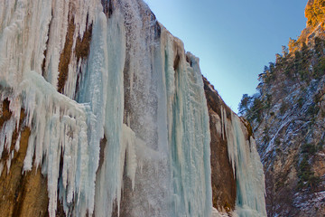 Chegem waterfalls in winter, icy water falls from the mountain