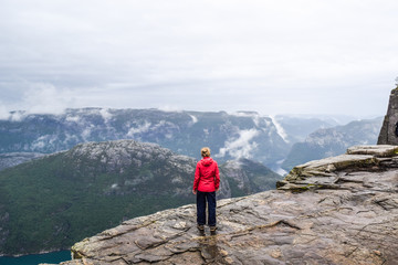 Girl on Prekestolen or Pulpit Rock in the rain. Norway.