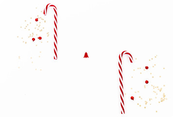 Modern Christmas background with candy canes and confetti in red and white background with copy space 