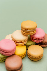 Colored tasty  macaroons over a green background