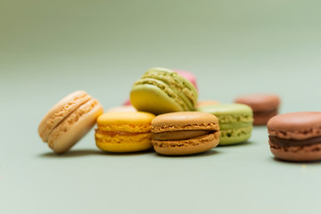 Colored tasty  macaroons over a green background