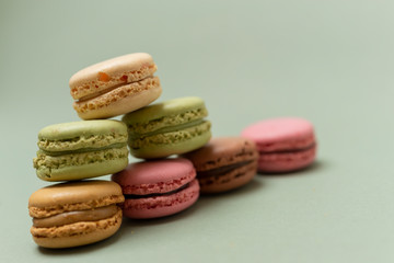 Colored tasty  macaroons over a green background