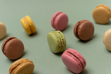 Colored tasty  macaroons over a green background