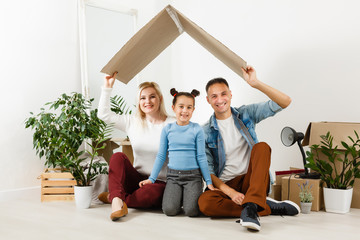 Happy family with cardboard boxes in new house at moving day.