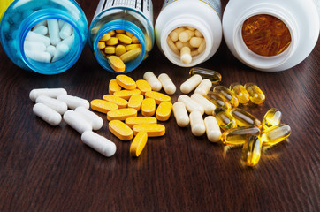 Plastic botlles with vitamin pills on wooden background - selective focus