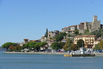 Fototapeta na wymiar Passignano on Trasimeno Lake panorama from the port of the village built on a rocky spur around a Lombard fortification.